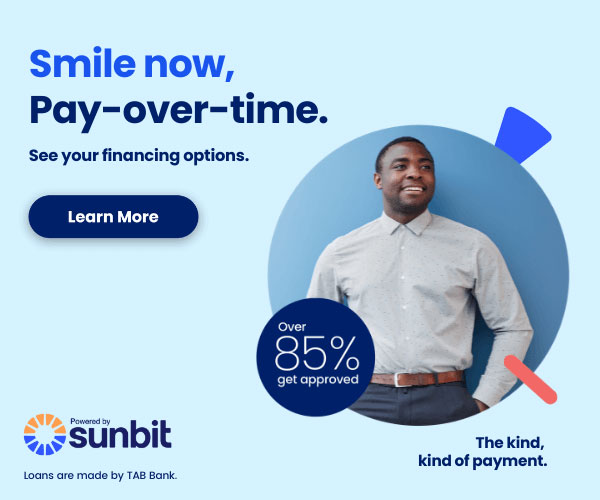 The image is an advertisement featuring a man in a blue shirt standing against a blue background, smiling at the camera. He has a beard and is wearing a dark tie with a light-colored shirt. Below him, there s text that reads  Smile now, pay-over-time,  followed by a call to action button labeled  Learn more.  To the right of the man, there are icons indicating various financing options such as  See your financing options  and  8  APR.  The bottom left corner has a logo with the text  Sunbit  beneath it. The overall style of the image is clean and modern, utilizing a color scheme that includes blue, white, and black.