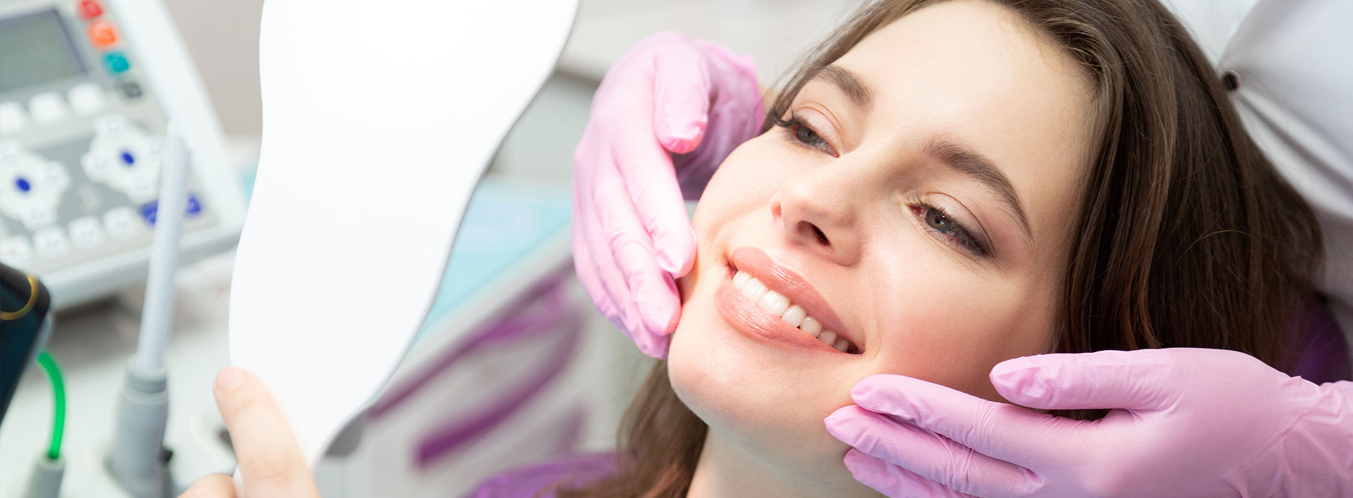 A woman receiving dental treatment, with a dentist adjusting her mouthpiece.