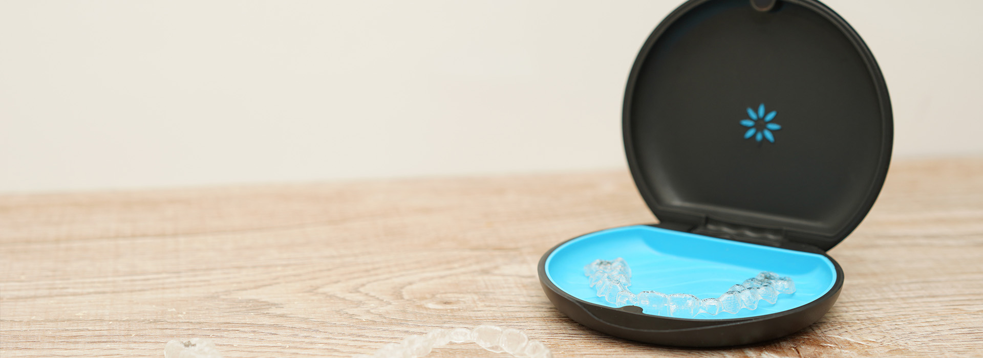 The image shows a smart speaker with a blue light on, placed against a white background.