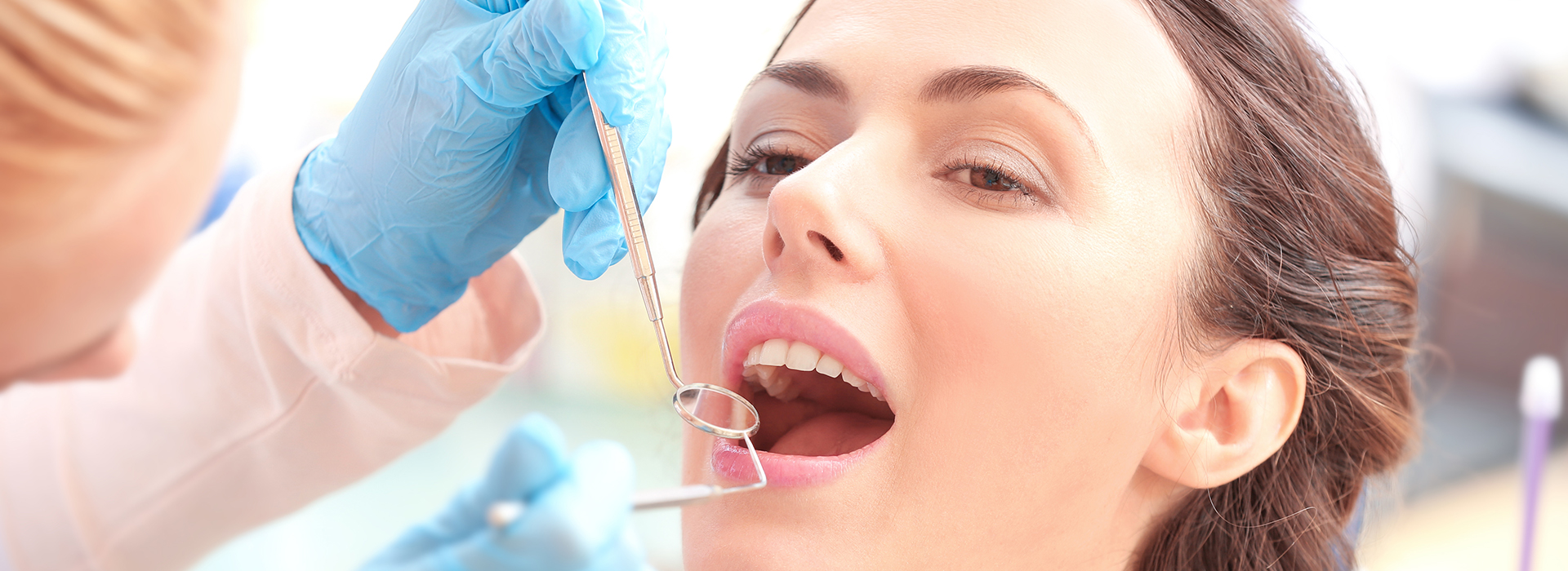 A woman receiving dental care, with a dentist performing a procedure.