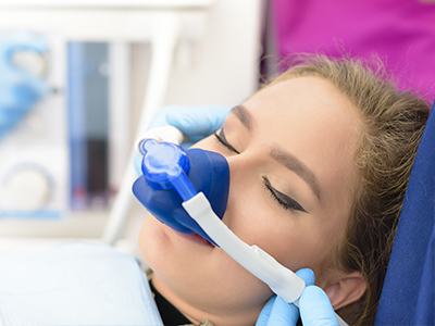 A person receiving oxygen therapy with a medical device, attended by a healthcare professional.