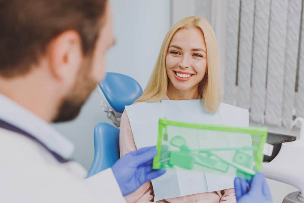 Close,Up,Stomatologist,Young,Man,Doctor,In,Gown,Give,Kit