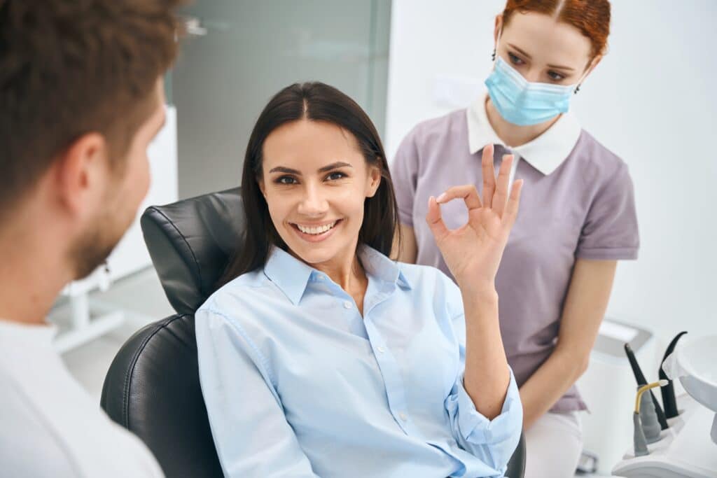 Smiling,Woman,Showing,Ok,Gesture,Sign,Sitting,In,Orthodontic,Chair